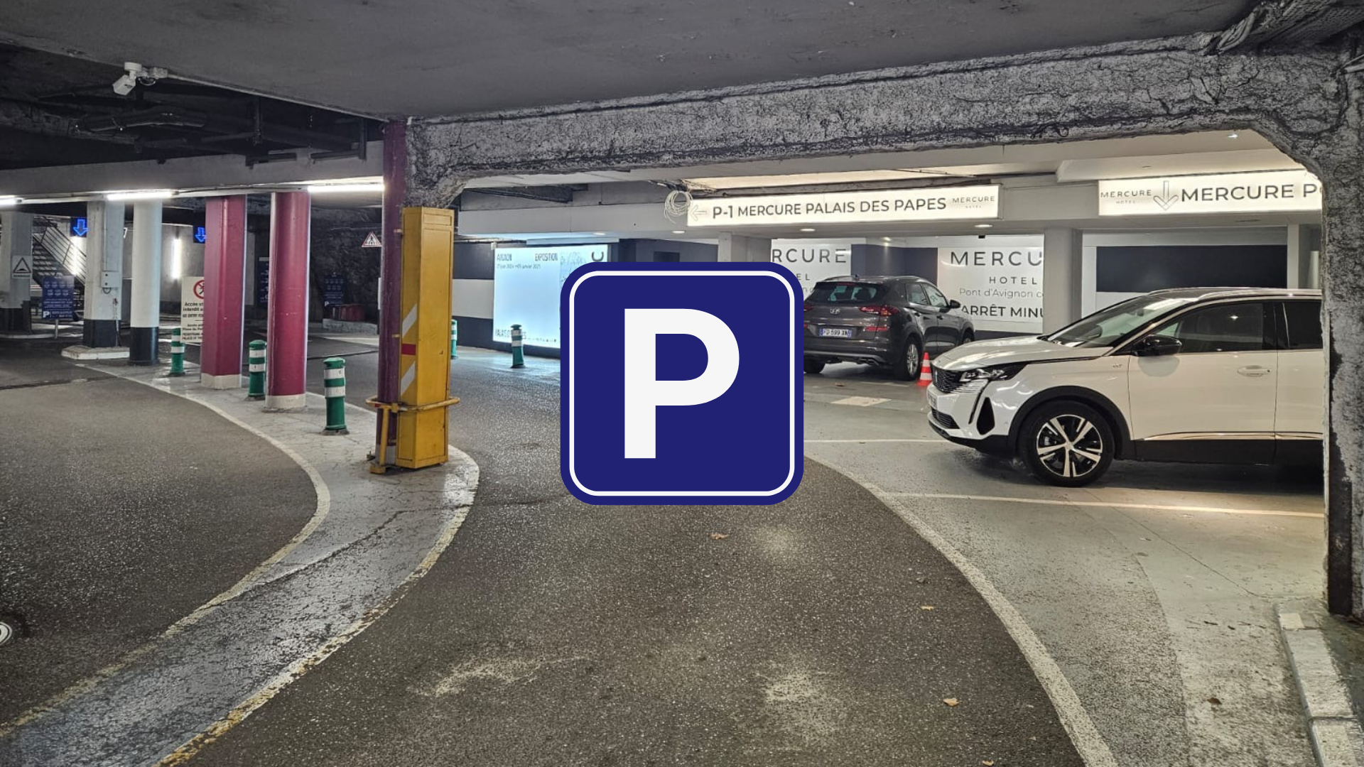 Parking souterrain d'hôtel avec voitures garées.