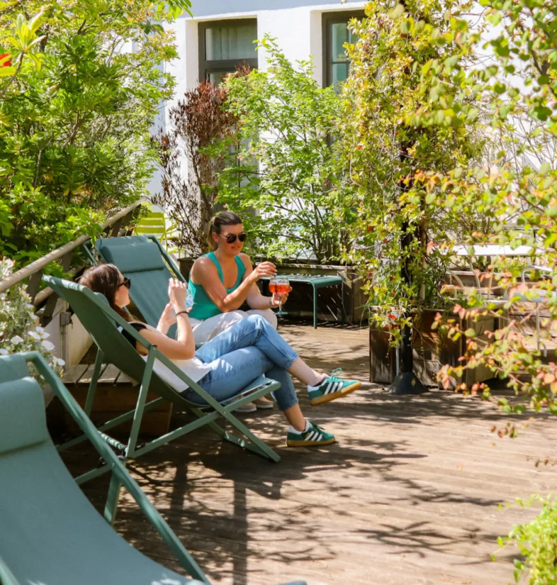 Deux personnes se détendent sur une terrasse ensoleillée.