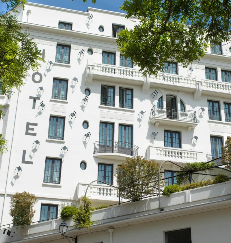 Façade d'un hôtel moderne blanc avec balcons.